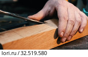 Carpentry industry - a man woodworker cutting out and smoothing the recess on the wooden detail with a chisel. Стоковое видео, видеограф Константин Шишкин / Фотобанк Лори