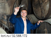 Attentive taster posing with glass of wine. Стоковое фото, фотограф Яков Филимонов / Фотобанк Лори