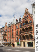 Riga Art Nouveau (Jugendstil), red brick house with large balconies and weather vane on tower in the central area of city (2014 год). Редакционное фото, фотограф Юлия Бабкина / Фотобанк Лори