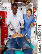 Emergency doctor resuscitating male patient with help of defibrillator. Стоковое фото, фотограф Яков Филимонов / Фотобанк Лори