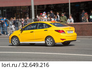 Желтый автомобиль такси Хундай Солярис едет по Новому Арбату в Москве (2018 год). Редакционное фото, фотограф Малышев Андрей / Фотобанк Лори