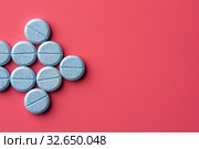 Close-up of bkue pills lie on a pink surface. Стоковое фото, фотограф Pavel Biryukov / Фотобанк Лори