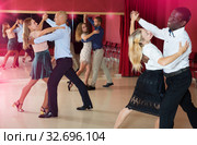 Positive adult couples dancing tango together in modern studio. Стоковое фото, фотограф Яков Филимонов / Фотобанк Лори