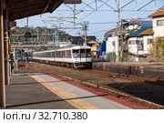 Old train by West Japan Railway Company (JR West) comes to Miyajimaguchi Station. It is on Sanyo Main in Hatsukaichi, Hiroshima. Way to Itsukushima (2013 год). Редакционное фото, фотограф Кекяляйнен Андрей / Фотобанк Лори