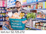 Tired male with heavy shopping basket. Стоковое фото, фотограф Яков Филимонов / Фотобанк Лори