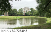 The Vorontsov Park at rainy day. Rain drops fall on water surface. Dormitory district with dwelling houses is in Kirovsky district, St. Petersburg, Russia (2019 год). Стоковое видео, видеограф Кекяляйнен Андрей / Фотобанк Лори