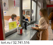 Рабочие места операторов-кассиров МЦК, оборудованные системой для слабослышащих девушка стоит в кассу (2019 год). Редакционное фото, фотограф Кузнецов Максим / Фотобанк Лори