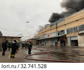 Пожарная команда тушит пожар на складе. Пожарный вертолет (2019 год). Редакционное фото, фотограф Кузнецов Максим / Фотобанк Лори