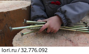 Child holding bunch of steel screws. Стоковое видео, видеограф Ekaterina Demidova / Фотобанк Лори