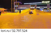 Дети катаются с ледяной горки на городской площади. Children ride on an ice slide in the town square. (2019 год). Редакционное видео, видеограф Евгений Романов / Фотобанк Лори