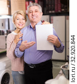 Pretty mature couple buying on credit agreement for home appliances. Стоковое фото, фотограф Яков Филимонов / Фотобанк Лори