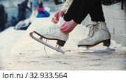 A woman tie up her figure skates. Стоковое видео, видеограф Константин Шишкин / Фотобанк Лори