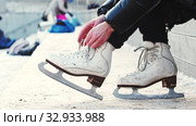 A woman untie her figure skates. Стоковое видео, видеограф Константин Шишкин / Фотобанк Лори