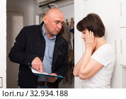 Businessman trying to collect arrearages from woman at home door. Стоковое фото, фотограф Яков Филимонов / Фотобанк Лори