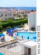 PAPHOS, CYPRUS-CIRCA SEP, 2013: Buildings and poolside of Kissos hotel with resting people. It is a family resort and three stars hotel located next to the Tombs of the Kings and the Paphos Lighthouse. Редакционное фото, фотограф Кекяляйнен Андрей / Фотобанк Лори