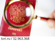 Российский заграничный паспорт под лупой на белом фоне. Стоковое фото, фотограф Николай Винокуров / Фотобанк Лори