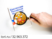 Мужчина изучает Конституцию Российской Федерации под лупой на белом фоне. Стоковое фото, фотограф Николай Винокуров / Фотобанк Лори