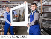 Production workers in coverall with different finished PVC profiles and windows at factory. Стоковое фото, фотограф Яков Филимонов / Фотобанк Лори