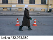 Пожилая женщина в пальто идет по улице в городе (2017 год). Редакционное фото, фотограф Иван Козлович / Фотобанк Лори