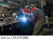 Welder works in a small workshop. Стоковое фото, фотограф Евгений Харитонов / Фотобанк Лори