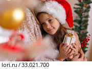 The girl snuggled up to her mother's chest, in the New Year's interior. Стоковое фото, фотограф Иванов Алексей / Фотобанк Лори