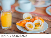 Tasty exotic fruits - ripe passion fruit, mango on breakfast at outdoor restaraunt. Стоковое фото, фотограф Дмитрий Травников / Фотобанк Лори