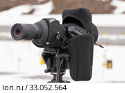 Close-up view of professional sports monocle Carl Zeiss looking at shooting range of biathlon stadium. Junior biathlon competitions East of Cup (2019 год). Редакционное фото, фотограф А. А. Пирагис / Фотобанк Лори