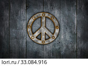 rusty riveted peace symbol on dirty wooden wall - 3d illustration. Стоковое фото, фотограф Jörg Röse-Oberreich / PantherMedia / Фотобанк Лори