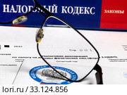 Бланк налоговой декларации на доходы физических лиц (форма 3НДФЛ) на фоне налогового кодекса Российской Федерации. Стоковое фото, фотограф Николай Винокуров / Фотобанк Лори