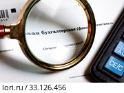 Бланк бухгалтерской финансовой отчетности под увеличительным стеклом и калькулятор на белом фоне. Стоковое фото, фотограф Николай Винокуров / Фотобанк Лори