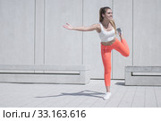 Happy Sporty Pretty Girl Doing an Outdoor Exercise. Стоковое фото, фотограф Piotr Stryjewski / PantherMedia / Фотобанк Лори