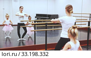 Young female ballet teacher and two little girls in classical dance school. Стоковое видео, видеограф Яков Филимонов / Фотобанк Лори