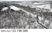 Южный Урал. Башкирское село Макарово в горах зимой. Southern Urals. Bashkir village of Makarovo in the mountains in winter. Aerial view. (2020 год). Стоковое видео, видеограф Евгений Романов / Фотобанк Лори