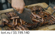 Waiter cuts fried pork ribs. Стоковое видео, видеограф Kozub Vasyl / Фотобанк Лори