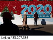 Баннер фестиваля Путешествие в Рождество надписью "2020 московские сезоны" в солнечный и бесснежный зимний день на площади Революции в центре города Москвы, Россия. Редакционное фото, фотограф Николай Винокуров / Фотобанк Лори