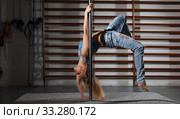 Woman practicing pole dancing in dark studio. Стоковое фото, фотограф Яков Филимонов / Фотобанк Лори