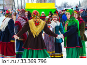 Девушки одетые в национальную старинную русскую одежду и яркие платки водят хоровод на празднике Масленицы. Город Бердск, Новосибирская область, Западная Сибирь, Россия (2020 год). Редакционное фото, фотограф Евгений Мухортов / Фотобанк Лори