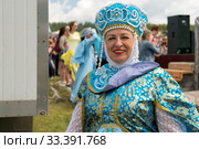 Улыбающаяся пожилая женщина в русском народном костюме на музыкальном фестивале "Каратаг". Красноярский край (2019 год). Редакционное фото, фотограф Светлана Попова / Фотобанк Лори