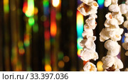 Vertically hanging garlands of popcorn for sports and movie news. On background dynamic gold background in shining lights and sparkling particles. 4K close up video. Стоковое видео, видеограф Dmitry Domashenko / Фотобанк Лори