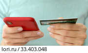 Womans hands holding a credit card and using cell phone. Стоковое фото, фотограф Ekaterina Demidova / Фотобанк Лори