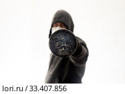 Угроза насилия от агрессивного мужчины в толстовке с капюшоном, который тычет в лицо бейсбольной битой. Стоковое фото, фотограф Sergei Gorin / Фотобанк Лори