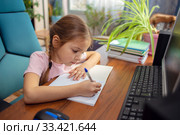 Girl schoolgirl does school homework at home in front of a computer. Стоковое фото, фотограф Екатерина Кузнецова / Фотобанк Лори