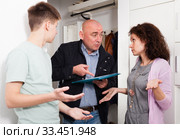 Woman and teen son talking to debt collector. Стоковое фото, фотограф Яков Филимонов / Фотобанк Лори