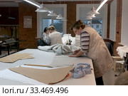 Раскрой ткани на фабрике "Крестецкая строчка" в поселке Крестцы Новгородской области (2019 год). Редакционное фото, фотограф Румянцева Наталия / Фотобанк Лори
