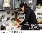 Немолодая женщина готовит пищу на кухне (2020 год). Редакционное фото, фотограф Игорь Низов / Фотобанк Лори