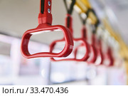 Interior elements of public transport - city bus grab handles - on a blurred background. Стоковое фото, фотограф Евгений Харитонов / Фотобанк Лори