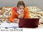 Заболевшая девочка на карантине учится с удаленно помощью ноутбука. Стоковое фото, фотограф Иванов Алексей / Фотобанк Лори
