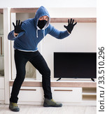 Man burglar stealing tv set from house. Стоковое фото, фотограф Elnur / Фотобанк Лори