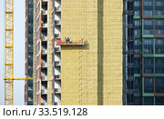 Работы по теплоизолированию стены современного жилого дома. Москва. Россия (2020 год). Редакционное фото, фотограф E. O. / Фотобанк Лори