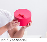 Young man with gift bag at home preparing suprise for wife. Стоковое фото, фотограф Elnur / Фотобанк Лори